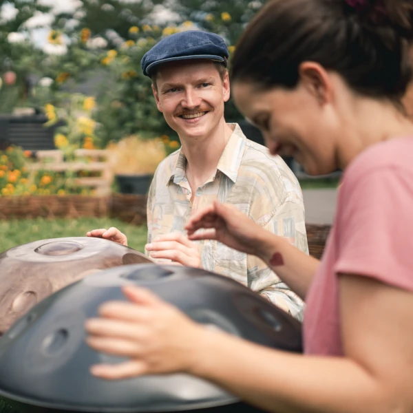 Was ist eine Handpan - Zwei Personen spielen Handpan im Garten