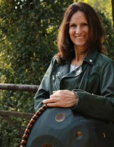 Jutta Allmann spielt Handpan unter Baum sitzend